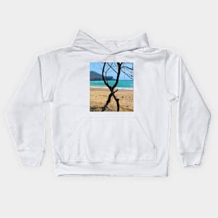 View through two curved pine tree trunks to a sand beach Kids Hoodie